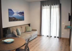 a living room with a couch and a table at Baia delle Rose Holiday Apartments in Costa Volpino