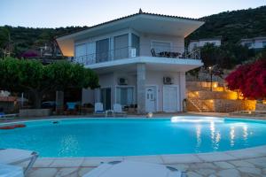 a villa with a swimming pool in front of a house at InstaView Tolo in Tolo