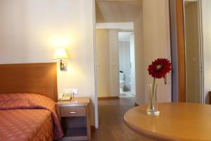 a hotel room with a vase with a flower on a table at Strada Marina Hotel in Zakynthos