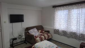 a small room with a chair and a television at Villa Shine apartment 2 in Radožda