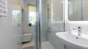 a bathroom with a shower and a toilet and a sink at Villa Dzika Plaża in Gdańsk +46 photos