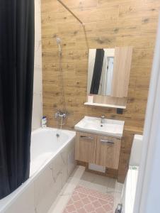 a bathroom with a tub and a sink and a mirror at Satsiti Блок Н in Astana +8 photos