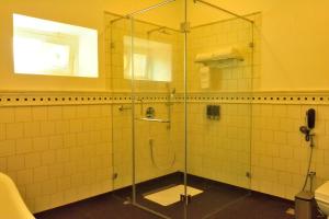 a bathroom with a shower with a glass door at The Tredis Heritage by the Lake in Kodaikānāl