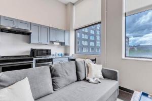 a living room with a couch and a kitchen at CozySuites Modern 1BR in Downtown Pitts #17 in Pittsburgh