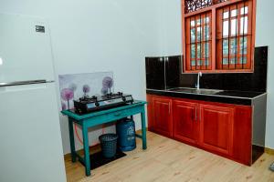 Una cocina con una mesa azul y un fregadero. en Villa Kaluperuma, en Beruwala 11 fotos más