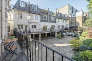 an apartment with a balcony with a courtyard at Luxurious 4 bedroom home in Kensington in London