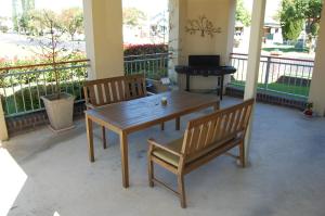 una mesa de madera y 2 sillas en el porche en Elite Motor Inn, en Armidale