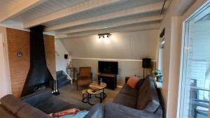 a living room with a couch and a fireplace at Gramsbergs Huuske in Gramsbergen