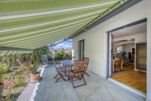 un patio avec une table et des chaises dessus dans l'établissement Villa de charme proche du lac, à Sciez