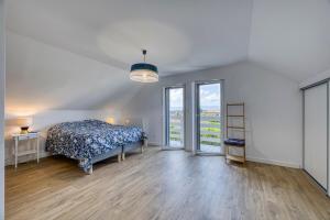 - une chambre avec un lit et des portes coulissantes en verre dans l'établissement Villa de charme proche du lac, à Sciez