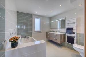 une salle de bain avec une baignoire, des toilettes et un lavabo dans l'établissement Villa de charme proche du lac, à Sciez