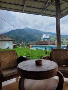 a table and chairs with a view of a building at Ayem Tentrem Homestay in Selo