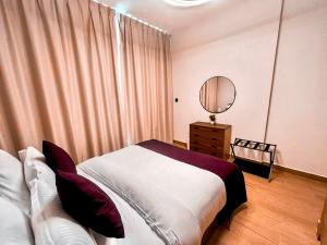 a bedroom with a large bed and a mirror at 1 Bedroom 1 Min walking to Cleveland and Galleria Mall by Central Stay in Abu Dhabi