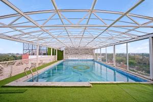 a large swimming pool with a roof on a building at Padmshree Palace in Ayodhya