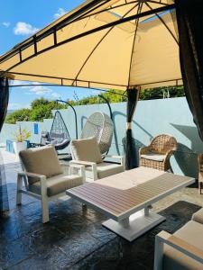 a patio with chairs and a table with an umbrella at Omaha Luxury B&B & SPA in Mthatha