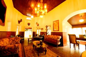 a living room filled with furniture and a chandelier at The Tredis Heritage by the Lake in Kodaikānāl