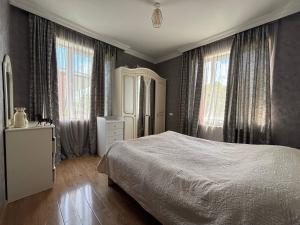 a bedroom with a bed and two windows at Maia's Farmstay in Dedoplis Tskaro