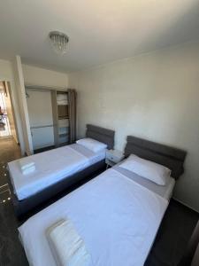 two beds in a hotel room with white sheets at Appartement Luxe & design Vue mer sur la Promenade des Anglais in Nice