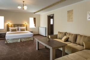 a hotel room with a bed and a couch at Emmar Zlatograd in Zlatograd