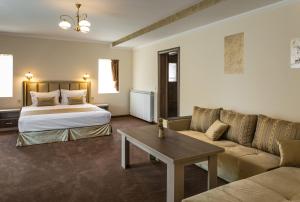 ズラトグラッドにあるEmmar Zlatogradのベッドとソファ付きのホテルルーム