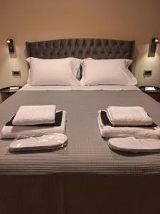 a bed with two towels and two plates on it at Casita in Ermoupoli
