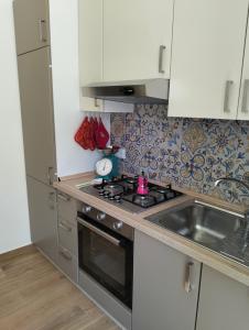 a small kitchen with a stove and a sink at Gallipoli Dragonfly Inn - Appartamento in Gallipoli +12 photos