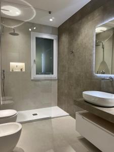 a bathroom with two sinks and a glass shower at Palazzo Tilde in Marsala +26 photos