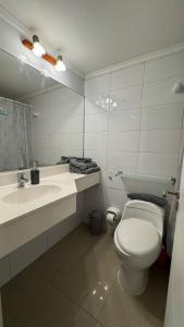 a bathroom with a toilet and a sink and a mirror at Lindo departamento vista Club de golf Santo domingo, cerca de parque Tricao in Santo Domingo +17 photos