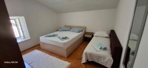 a small bedroom with two beds and a mirror at Downtown Dream Makarska in Makarska
