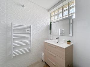 un baño con lavabo y espejo en Charmante maison 2 chambres avec cour et jardin, en Sainte-Savine 9 fotos más
