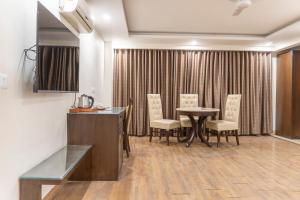a dining room with a table and chairs in a room at Hotel Central Palace in Dehradun