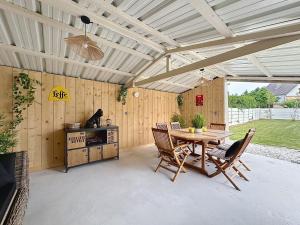 Un patio con mesa y sillas y una estufa. en Charmante maison 2 chambres avec cour et jardin, en Sainte-Savine
