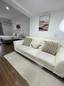 un divano bianco in un soggiorno con due letti di Omaha Luxury B&B & SPA a Mthatha