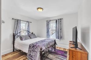 a bedroom with a bed and a flat screen tv at Cozy Getaway with Hot Tub, Patio & Fenced Yard home in Garfield Heights