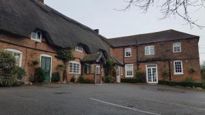 a large brick building with a thatched roof at Five Bells Wickham in Newbury