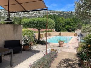 a patio with an umbrella and a swimming pool at La maison de Beaumes in Beaumes-de-Venise