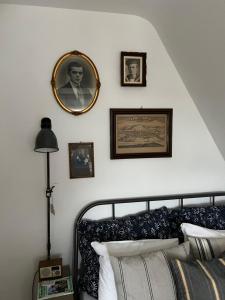 a bedroom with a bed and framed pictures on the wall at Domus Merian XII in Trier