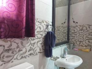 a bathroom with a sink and a mirror at Greenwood Cottage in Mukteswar