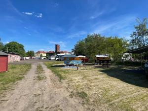 a dirt road leading to a campground with tents at Cabrio-Wohnwagen in Brandenburg an der Havel +10 photos