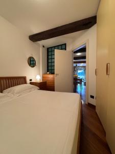 a bedroom with a white bed and a kitchen at Finestra sul Mare di Maury in Portovenere