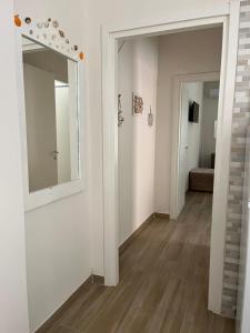a hallway with a mirror and a hallway with a couch at Mary appartament in Marina di Camerota +19 photos
