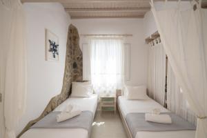 a bedroom with two beds and a window at Almyra Home in Ornos