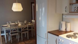 cocina con mesa de comedor con sillas y nevera en Villa Gården, en Vidsel