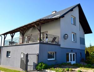 a large white house with a balcony at Noclegi Bero Fejn in Lipusz