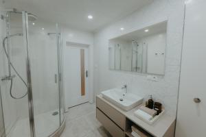 a white bathroom with a sink and a shower at Contessa Apartments in Košice +28 photos
