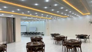 a room with tables and chairs and a projection screen at Chinor Hotel Fergana in Fergana +99 photos