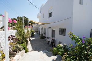 a pathway leading to a white building with flowers at PAROS APARTMENT MELAS b1 in Parikia