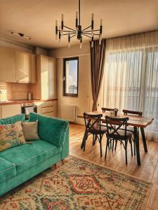 a living room with a green couch and a table at Cazare Apartmente in SolidHouse Mamaia in Mamaia