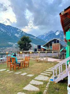 Eine Person sitzt an einem Tisch mit Blick auf die Berge in der Unterkunft Kaira huts in Manali