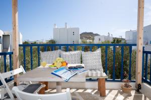 a table on a balcony with a drink and fruit on it at Almyra Home in Ornos